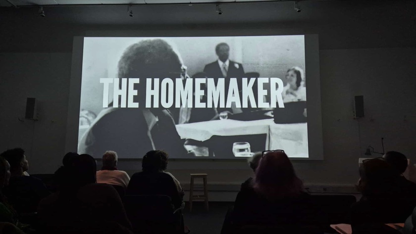 Audience seated in a screening room with The Homemaker projected on screen
